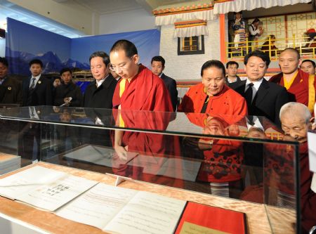 The 11th Panchen Lama Erdeni Gyaincain Norbu (front) looks at the exhibits during an exhibition titled 