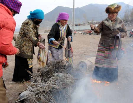 Local villagers burn joss sticks during a ceremony to mark the start of the spring farming season at Shexing Village, Doilung Deqen County, southwest China's Tibet Autonomous Region, March 15, 2009. (Xinhua/Soinam Norbu)