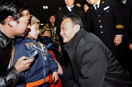 Wu Bangguo (C), chairman of the Standing Committee of the National People's Congress (NPC), China's top legislature, talks to passengers at Beijing West Railway Station in Beijing, China, Feb. 3, 2008.
