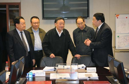 Wu Bangguo (C), chairman of the Standing Committee of the National People's Congress (NPC), China's top legislature, listens to an official's report at the Railway Ministry control center in Beijing, China, Feb. 3, 2008. 