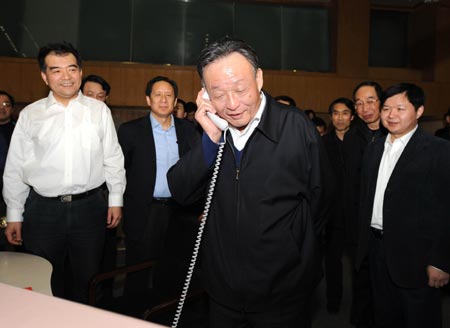 Wu Bangguo (C), chairman of the Standing Committee of the National People's Congress (NPC), China's top legislature, speaks over the phone to a train driver at the Railway Ministry control center in Beijing, China, Feb. 3, 2008.