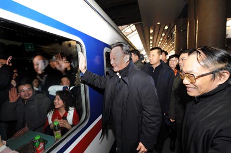 Wu Bangguo (C), chairman of the Standing Committee of the National People's Congress (NPC), China's top legislature, waves to passengers at the platform of Beijing West Railway Station in Beijing, China, Feb. 3, 2008. 