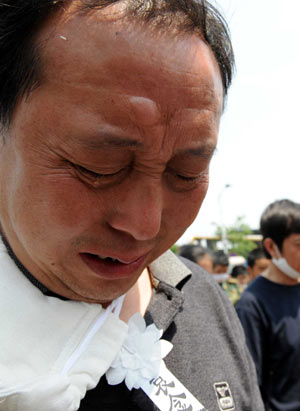 A worker of Sichuan Dongfang Steam Turbine Plant mourns during a silent tribute in Hanwang town of Mianzhu in the quake-hit Sichuan Province, southwest China, May 19, 2008. 