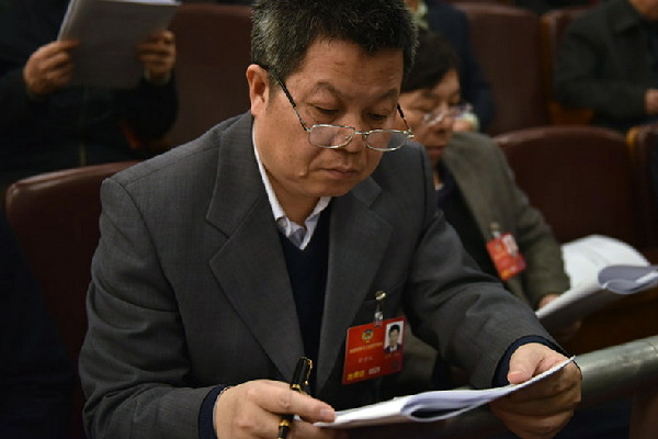 代表在阅读政府工作报告。人民网记者 李毓涵 摄