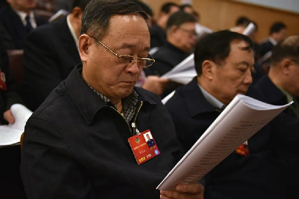 代表在阅读政府工作报告。人民网记者 李毓涵 摄