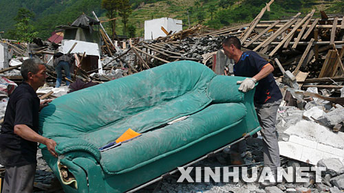 5月19日，一家人从废墟中扒出沙发，这是家中剩下的最大物件。 四川省什邡市蓥华镇仁和村三组的梁正彬一家很幸运，大地震发生时，包括老父母和年幼女儿在内的全家5口人都跑出了轰然倒塌的房屋。“平安就是福！”他们默默收拾废墟中的家，准备重建家园。