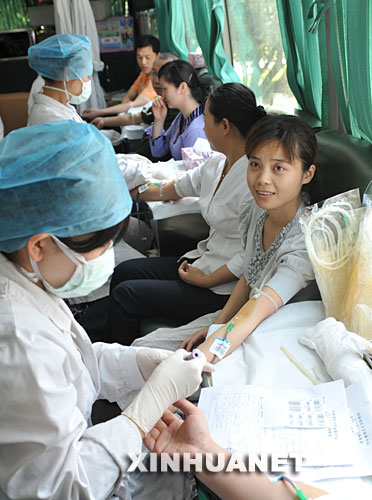 5月14日，郑州市委干部肖静在流动献血车上献血。当日，数百名郑州市直机关干部职工参加援助活动，并为汶川地震灾区的灾民献血。 　
