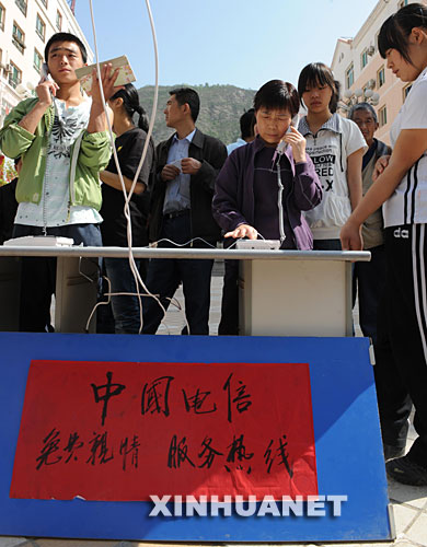 5月14日，甘肃省陇南市文县城区居民在免费的“亲情热线”前排队打电话。 5月12日，与四川省接壤的甘肃省文县发生强烈地震后，当地电信部门在城区设置了免费的亲情服务热线，让当地居民与外地的亲友保持联络。