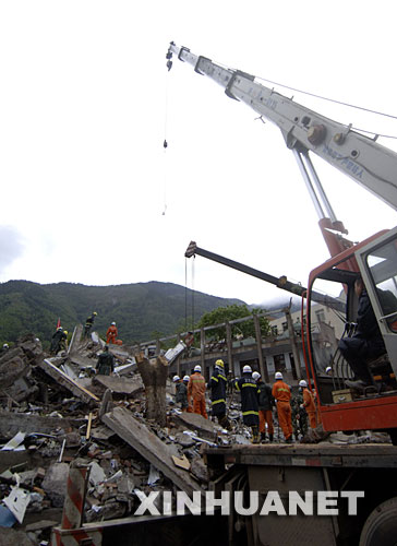 5月14日上午，救援人员在废墟中寻找被困学生。 受汶川地震影响，四川北川中学的教学楼倒塌，众多师生被埋在倒塌的校舍中。目前，救援行动正在进行中。 新华社记者 赵颖全摄 