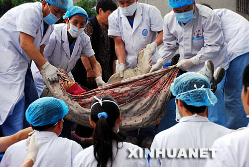5月15日，成都市华西医院的医护人员紧急抢救送来的灾区伤员。 在四川地震灾区，解放军、武警、公安、边防、消防官兵以及民兵、医疗救护人员和志愿者们，不怕危险，不畏疲劳，为抢救每一条宝贵的生命连续奋战。他们是最可爱的人。 新华社发(徐媛媛 摄) 