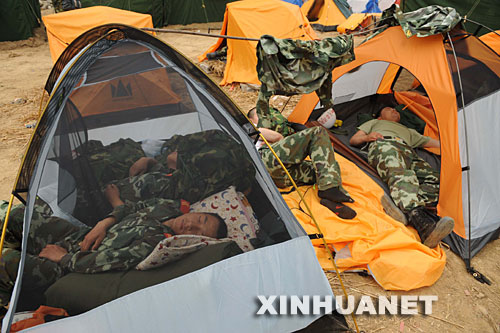 5月17日，在汶川地震重灾区北川县，从陈家坝抢险归营的武警官兵抓紧时间休息，等待替换战友。     当日是汶川地震发生后的第6天，解放军、武警官兵和预备役民兵以及社会各界的志愿者继续在各个灾区进行抢险搜救工作。 