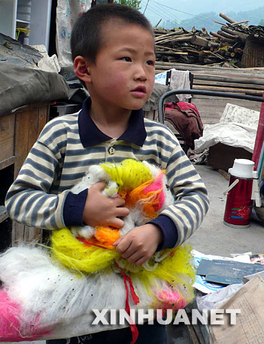 5月20日，四川省什邡市红白镇4岁的肖豪在自家废墟上捡回了自己的玩具。 从汶川大地震发生到现在已过去一周多的时间，一些在震灾中幸存下来的孩子心中留下伤痛，脸上难见笑容。娃娃不哭，灾难终会过去，你们是明天的希望。 新华社发（张晓理 摄） 